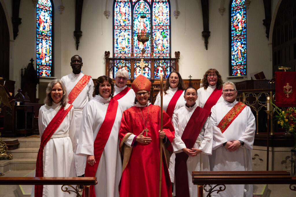 Image Description: The new deacons with their ordaining bishop, The Rt. Rev. Dr. Bonnie A. Perry, XI bishop of Michigan. From top left and clockwise: The Rev. John Atem, The Rev. Julianne Lark, The Rev. Theresa Williams, The Rev. Catheryn Stevens, The Rev. Jennifer Frechette, The Rev. Jessica Hart, The Rt. Rev. Bonnie Perry, The Rev. Stephanie Coté, and The Rev. Kathryn Christian.