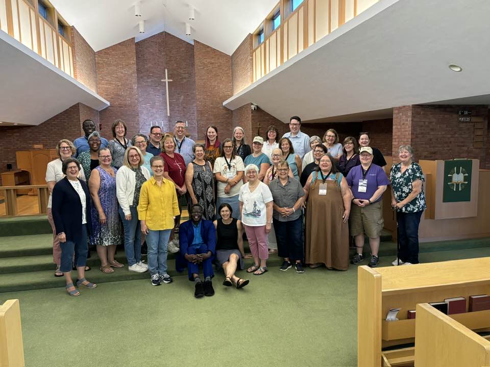 Image Description: A large group photo of the participants and trainers from this year's CCD week stands at the front of the nave of St. John's in Midland. They're all smiling broadly and genuinely. The photographer must have told a good joke!
