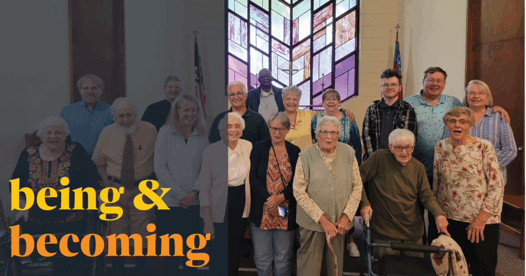 IMAGE DESCRIPTION: A group of 16 parishioners stand at the front of the nave at St. Barnabas in Portage and smile for the camera. Behind them is a beautiful, geometric stained glass window, the panes of which form a colorful gradient from purple, through mauves, into light greens and blues. There is a semi-transparent blue color block on the left side of the image. In a bold yellow and rich orange, text over the box reads, "being & becoming"