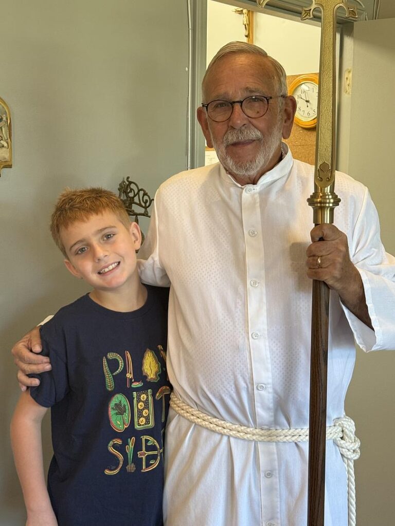 IMAGE DESCRIPTION: And older acolyte poses with his grandson.