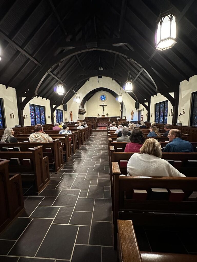 A photo of the nave of St. John's Episcopal Church in Sturgis. Folks are sitting in the pews, apparently waiting for the liturgy to begin.