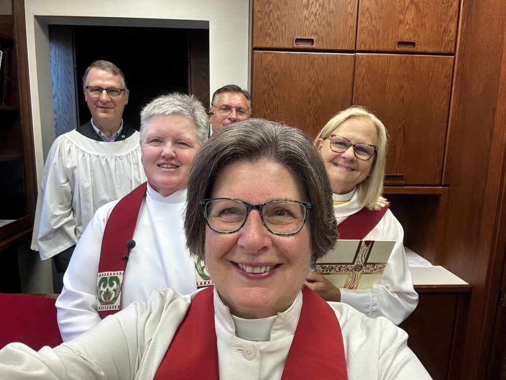 A selfie of five ministers in a sacristy before a church service, including the Revs. Canon Tracie Little, Kris Veldheer, and Liz Kinsey.