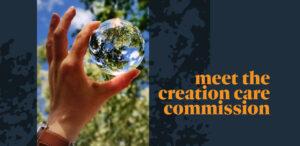 A hand holds a clear glass sphere reflecting trees and sky, with text beside it reading meet the creation care commission in orange on a dark background.