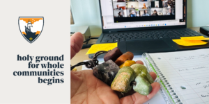 A hand holds several stone pendants over an open notebook with handwritten notes, in front of a laptop showing a video call. Text reads, holy ground for whole communities begins beside a crest logo.
